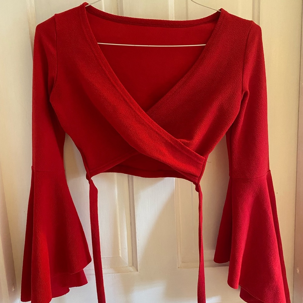 Red cropped trumpet sleeve top. Has a cute tie to accentuate the waist.